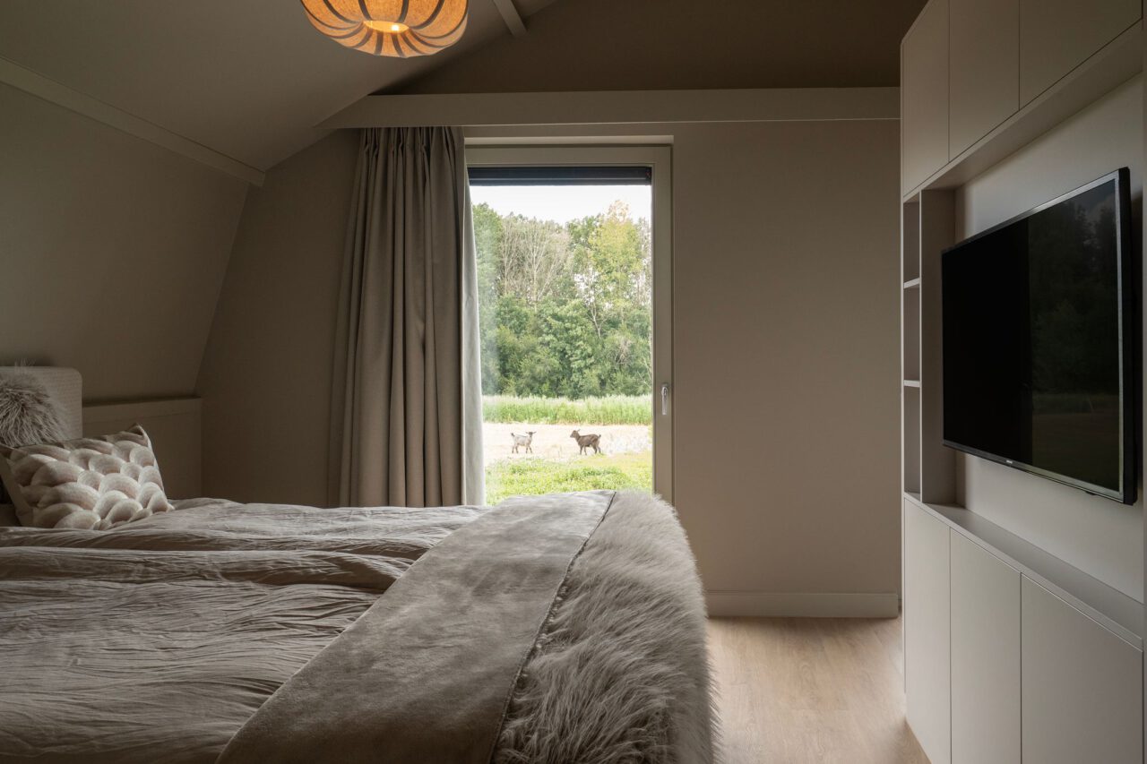 Slaapkamer met zicht op het veld in de wabi sabi woning Heenvliet